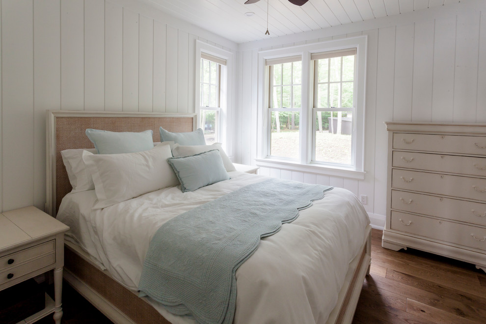 This is an example of a mid-sized traditional guest bedroom in Toronto with white walls and light hardwood floors.