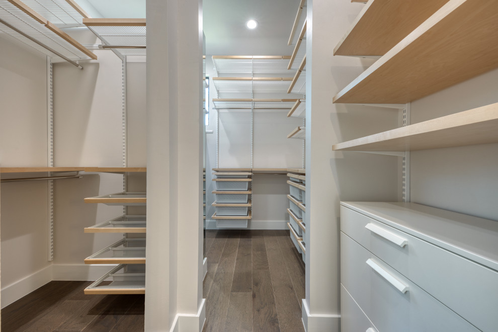 Photo of a large modern walk-in wardrobe in Austin with open cabinets, dark hardwood floors and brown floor.