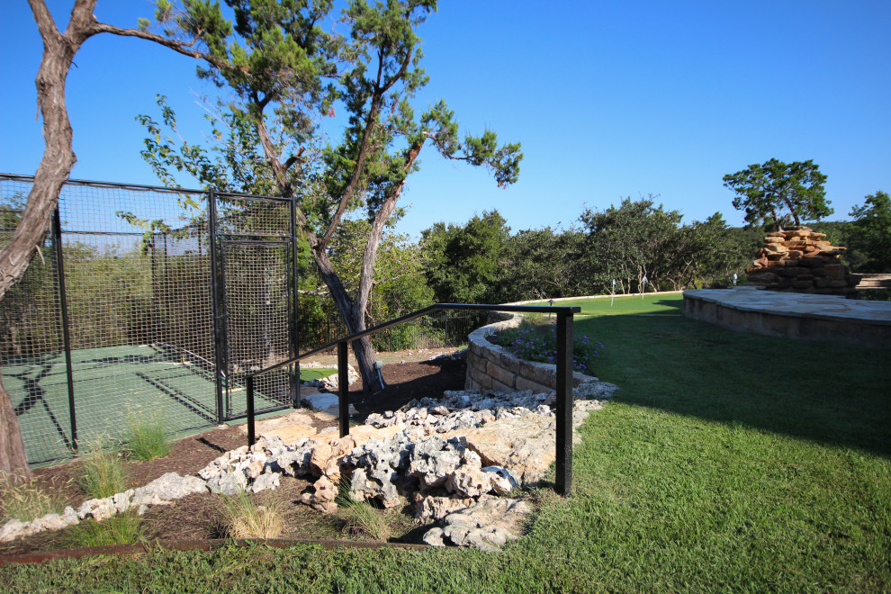 Idées déco pour un très grand jardin arrière contemporain avec un mur de soutènement et une clôture en métal.