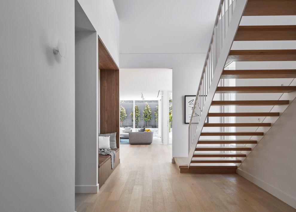 Modernes Wohnzimmer mit weißer Wandfarbe, Teppichboden, Gaskamin, Kaminumrandung aus Stein und braunem Boden in Melbourne