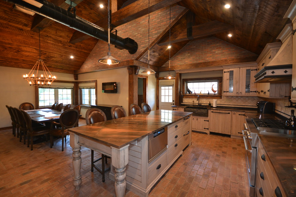 Large country l-shaped eat-in kitchen in New York with a farmhouse sink, beige cabinets, quartzite benchtops, beige splashback, limestone splashback, stainless steel appliances, brick floors, with island and orange floor.
