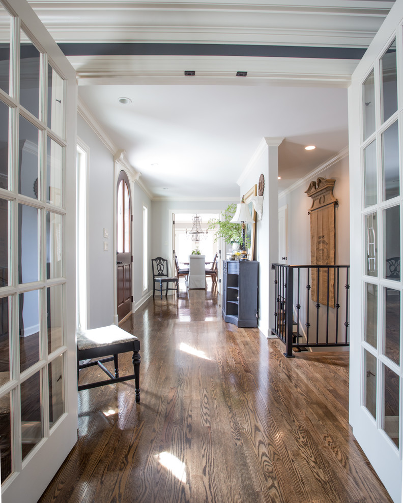 Design ideas for a large traditional hallway in Other with white walls, medium hardwood floors and brown floor.