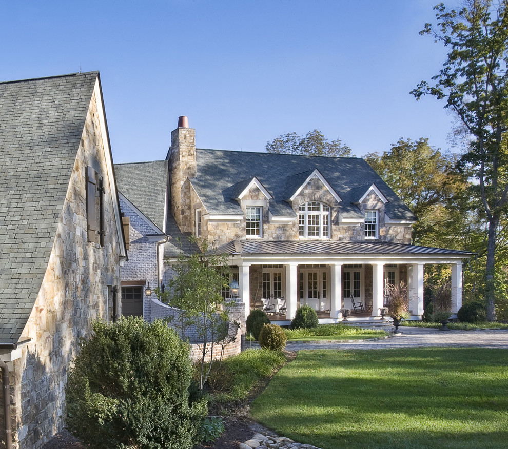Large traditional two-storey brown house exterior in Nashville with stone veneer, a gable roof and a shingle roof.