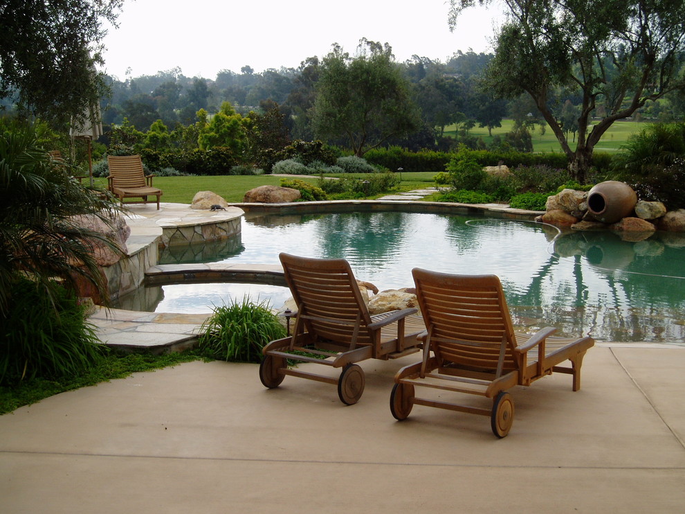 This is an example of a large mediterranean backyard custom-shaped pool in San Diego with concrete pavers.