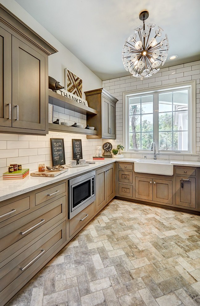 Mid-sized traditional u-shaped separate kitchen in Sacramento with a farmhouse sink, shaker cabinets, dark wood cabinets, marble benchtops, white splashback, subway tile splashback, stainless steel appliances, travertine floors, no island and multi-coloured floor.