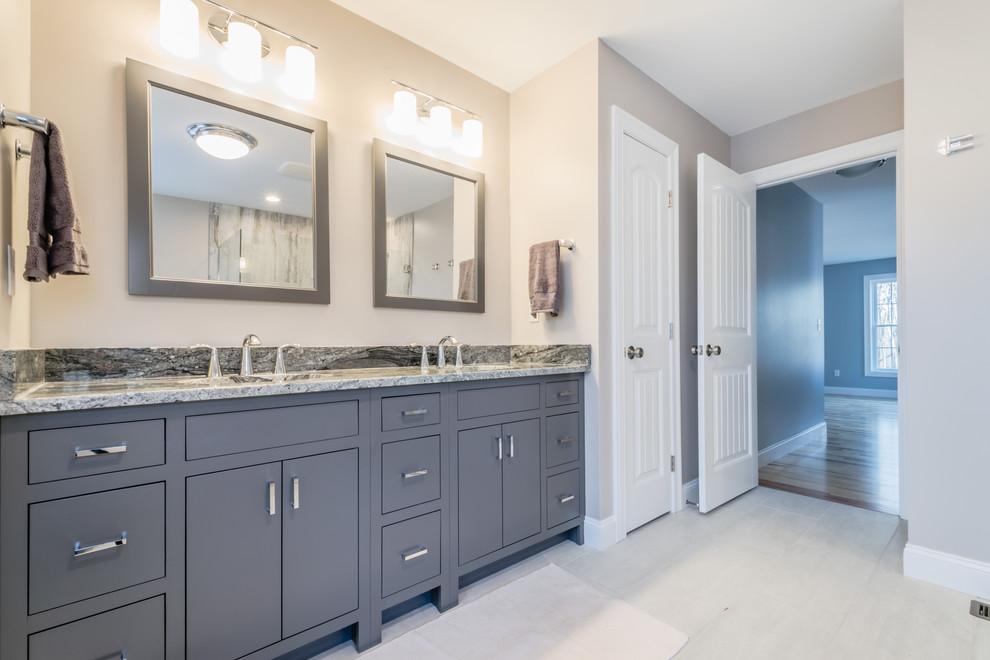 Inspiration for a mid-sized transitional master bathroom in New York with flat-panel cabinets, grey cabinets, an alcove shower, stone slab, grey walls, an undermount sink and granite benchtops.