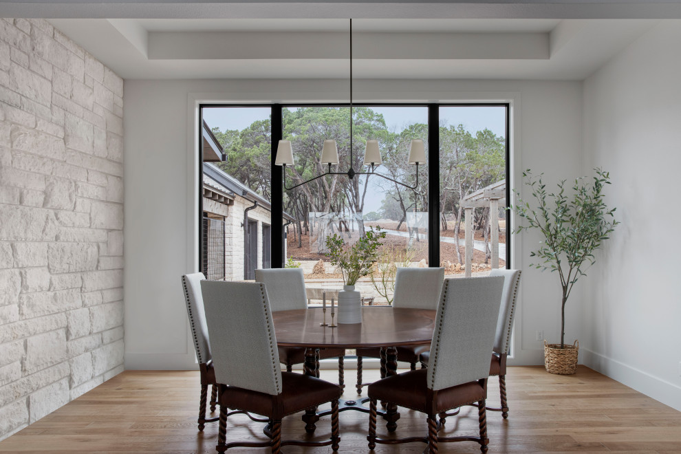 Photo of a large country dining room in Austin with white walls, light hardwood floors and recessed.