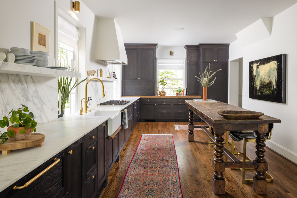 This is an example of a large country kitchen/diner in Atlanta with a belfast sink, dark wood cabinets, marble worktops, marble splashback, coloured appliances, dark hardwood flooring, brown floors and white worktops.