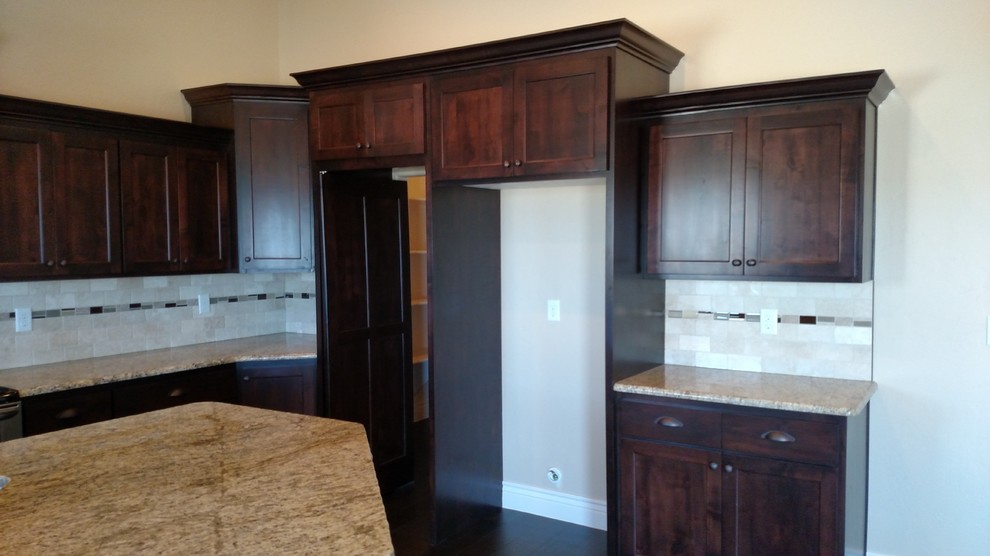 Large transitional u-shaped dark wood floor open concept kitchen photo with an undermount sink, shaker cabinets, dark wood cabinets, granite countertops, stone tile backsplash, stainless steel appliances and an island