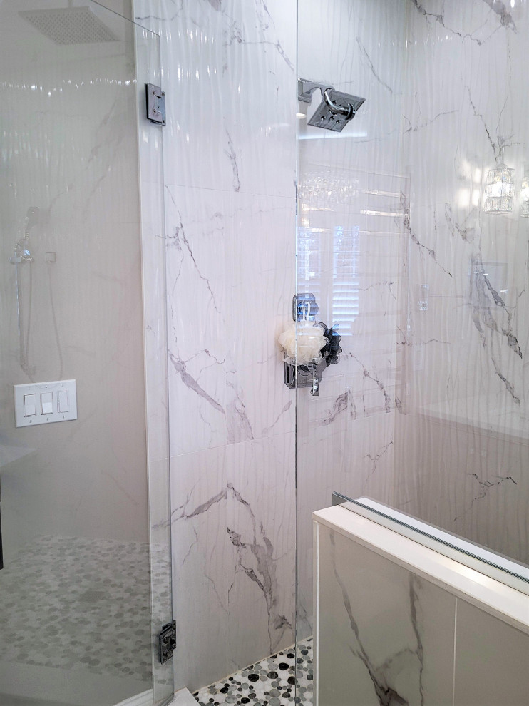 This is an example of a large transitional master bathroom in Boston with beaded inset cabinets, grey cabinets, a freestanding tub, a corner shower, a one-piece toilet, white tile, porcelain tile, grey walls, porcelain floors, an undermount sink, engineered quartz benchtops, white floor, a hinged shower door, white benchtops, a shower seat, a double vanity and a built-in vanity.