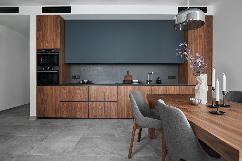 This is an example of a mid-sized single-wall eat-in kitchen in Moscow with a single-bowl sink, black cabinets, quartzite benchtops, grey splashback, porcelain splashback, panelled appliances, no island and grey benchtop.