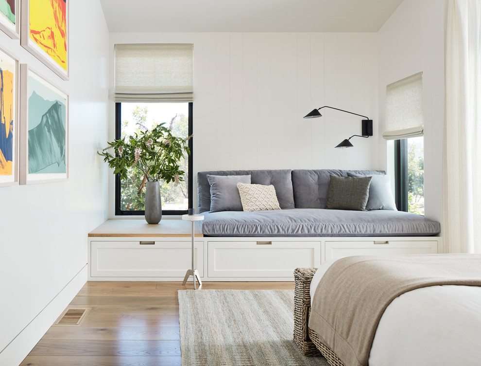 Country master bedroom in San Francisco with white walls, medium hardwood floors and no fireplace.