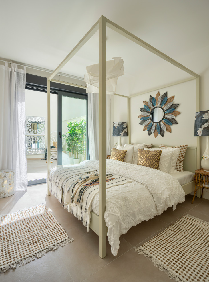 Inspiration for a mid-sized tropical master bedroom in Malaga with white walls, ceramic floors and beige floor.