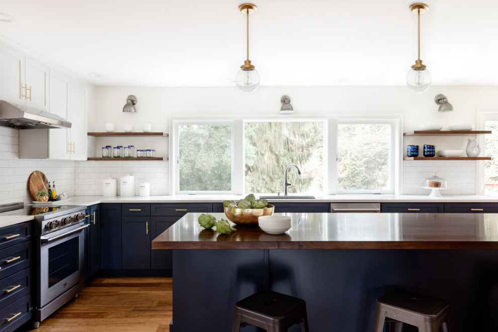Example of a large transitional l-shaped light wood floor and brown floor eat-in kitchen design in Seattle with a single-bowl sink, recessed-panel cabinets, blue cabinets, quartz countertops, white backsplash, ceramic backsplash, stainless steel appliances, an island and white countertops