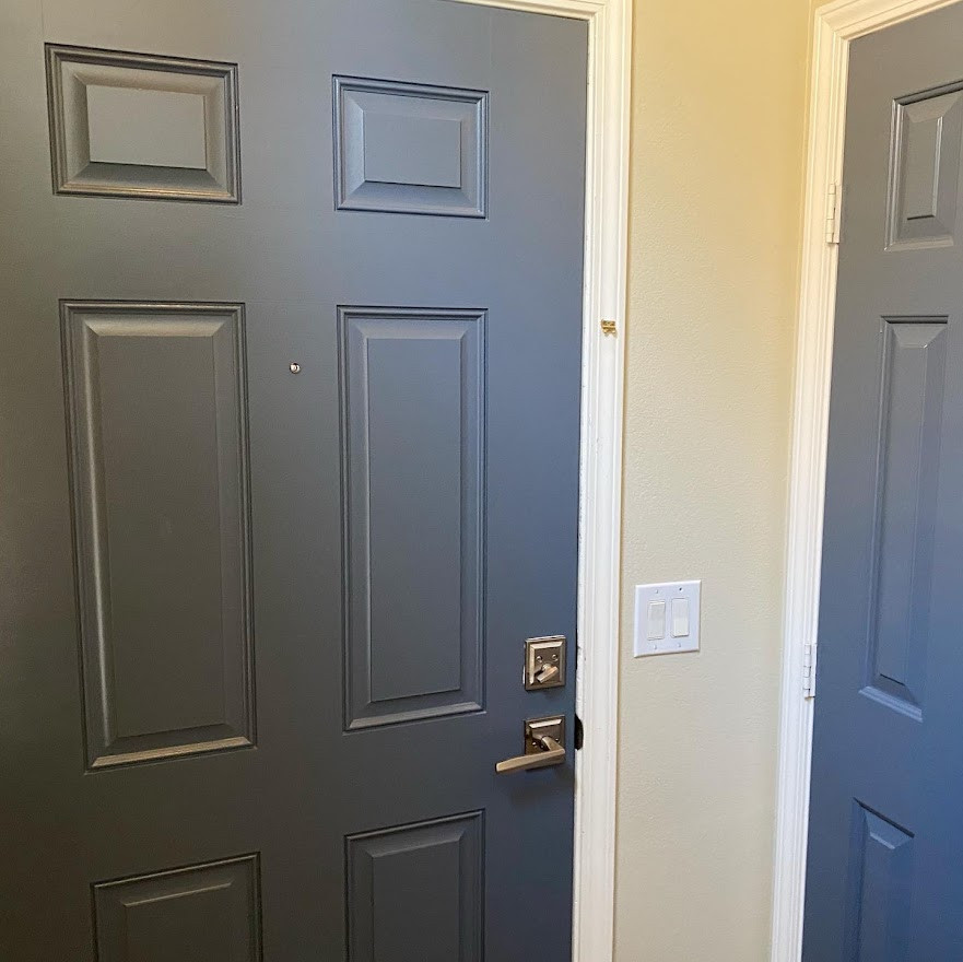 Small eclectic front door in Las Vegas with beige walls, vinyl floors, a single front door, a blue front door, grey floor and vaulted.