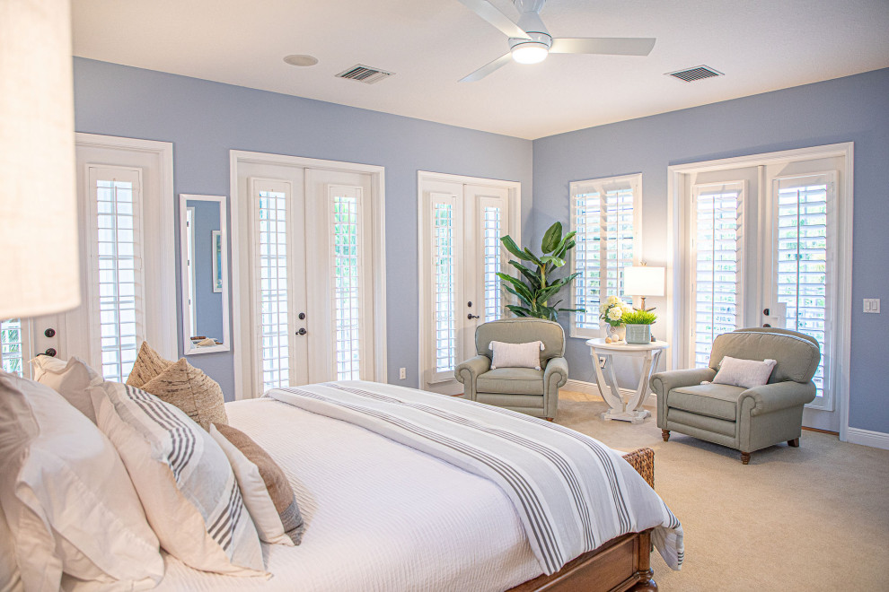 This is an example of a medium sized beach style guest bedroom in Tampa with multi-coloured walls, no fireplace, carpet, beige floors and wallpapered walls.