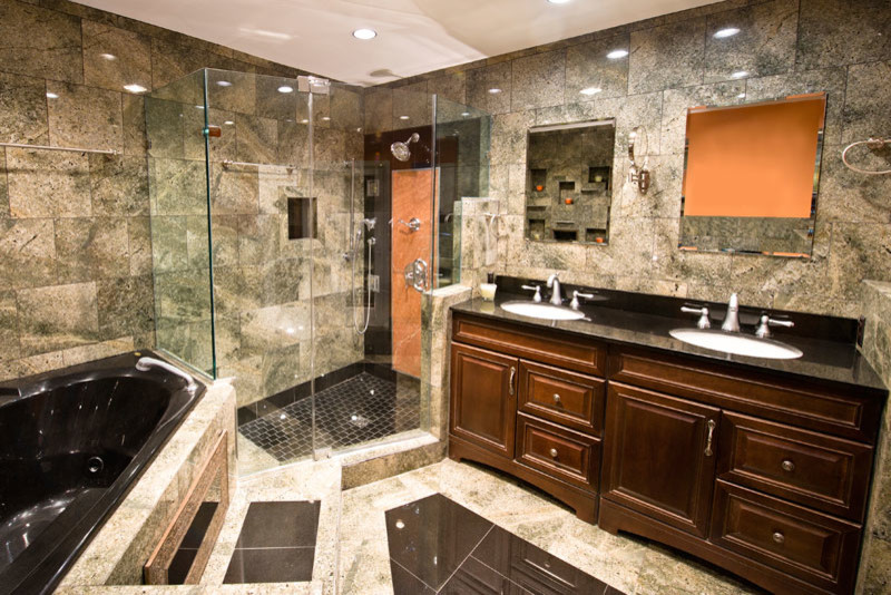 Mid-sized contemporary master bathroom in San Francisco with an undermount sink, raised-panel cabinets, dark wood cabinets, granite benchtops, a corner tub, a corner shower, gray tile and grey walls.
