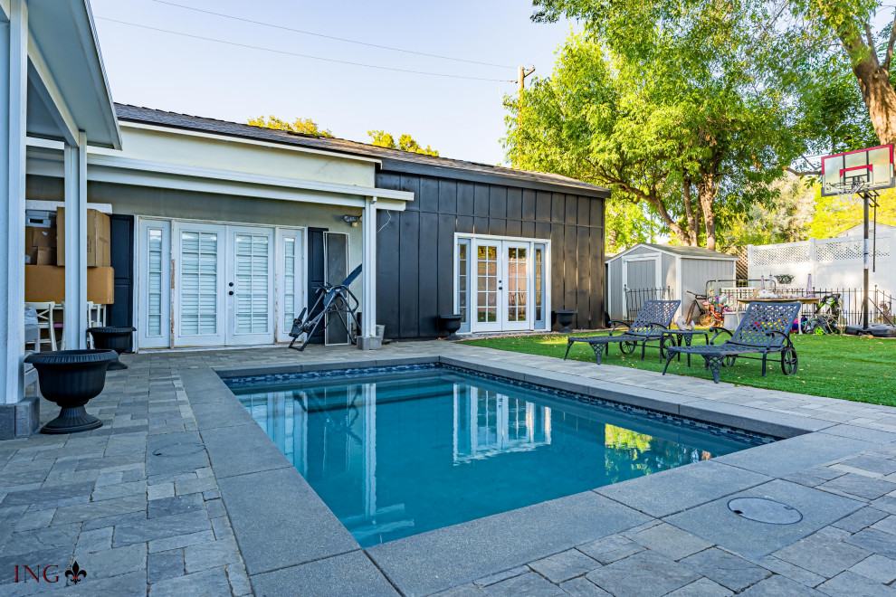 Foto de piscina natural contemporánea de tamaño medio rectangular en patio trasero con privacidad y adoquines de ladrillo