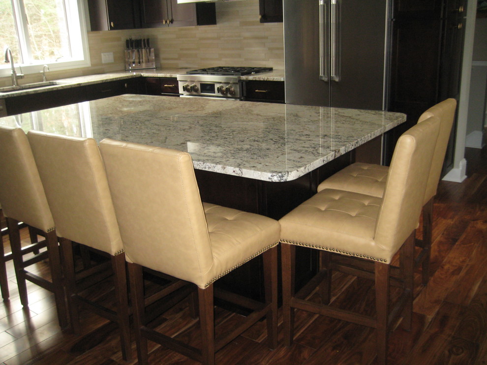 Example of a mid-sized mountain style l-shaped dark wood floor open concept kitchen design in Grand Rapids with a double-bowl sink, recessed-panel cabinets, dark wood cabinets, granite countertops, beige backsplash, matchstick tile backsplash, stainless steel appliances and an island