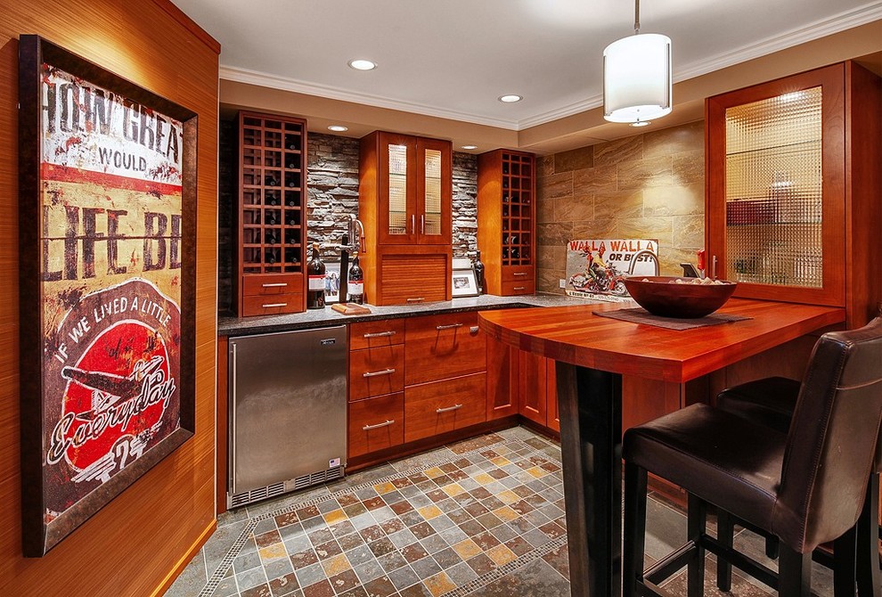 Photo of a country home bar in Seattle with an undermount sink, flat-panel cabinets, medium wood cabinets, wood benchtops, stone tile splashback and slate floors.