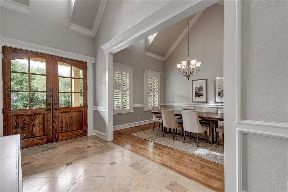 Inspiration for a country foyer in Austin with grey walls, ceramic floors, a double front door, a medium wood front door, beige floor and vaulted.