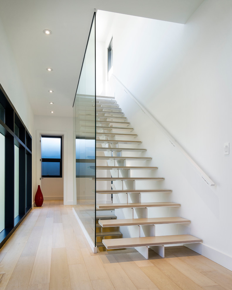 This is an example of a large modern wood straight staircase in Toronto with open risers.