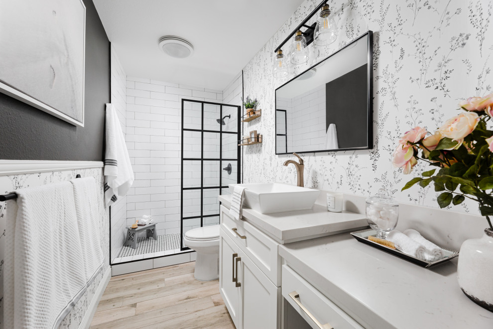 This is an example of a transitional bathroom in Los Angeles with shaker cabinets, white cabinets, an alcove shower, white tile, white walls, light hardwood floors, a vessel sink, beige floor, an open shower, white benchtops, a single vanity, a built-in vanity and wallpaper.