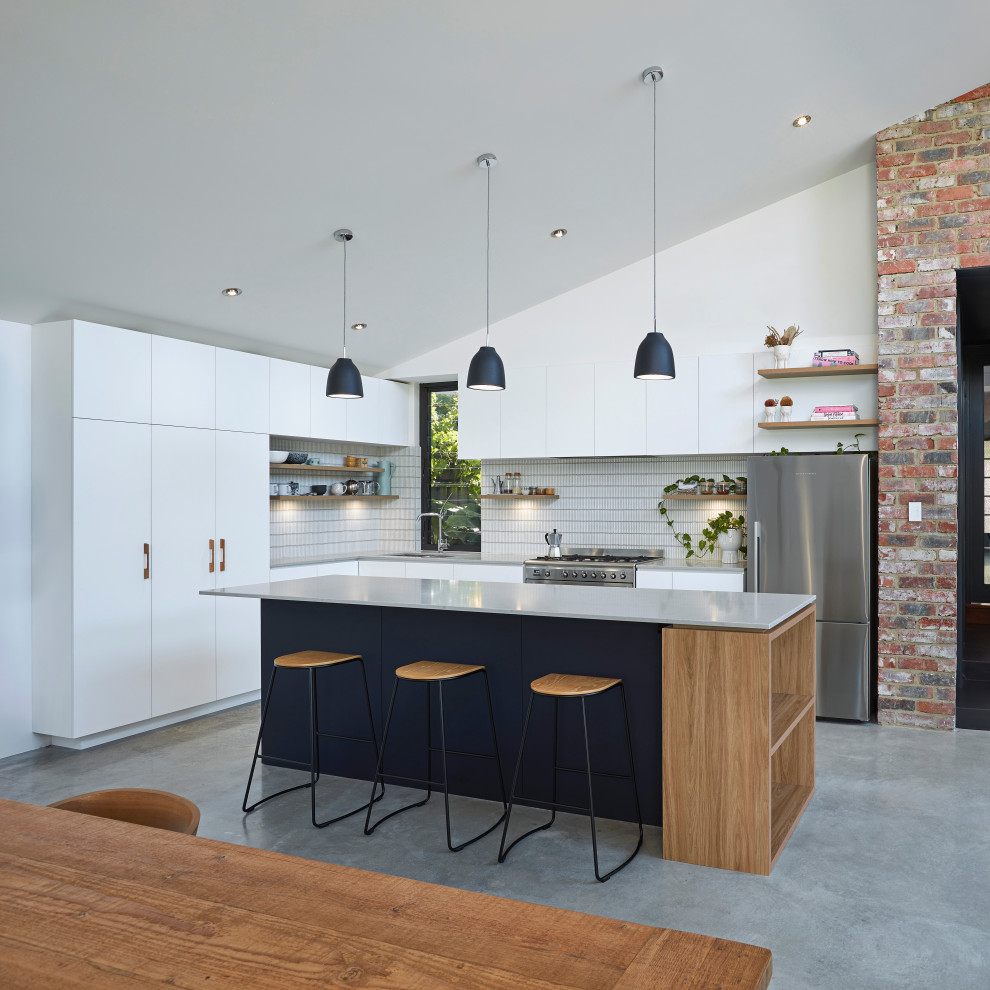 Design ideas for a small modern l-shaped open plan kitchen in Perth with a double-bowl sink, flat-panel cabinets, white cabinets, quartz benchtops, white splashback, ceramic splashback, stainless steel appliances, concrete floors, with island, grey floor and grey benchtop.