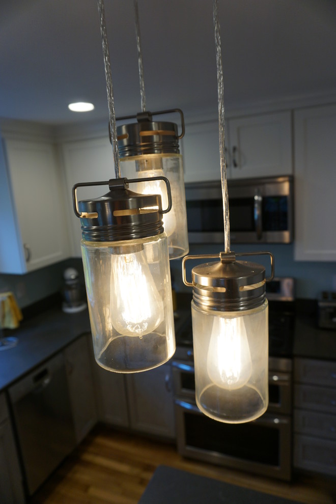 Inspiration for a mid-sized transitional u-shaped medium tone wood floor eat-in kitchen remodel in Boston with an undermount sink, shaker cabinets, gray cabinets, quartz countertops, black backsplash, stainless steel appliances and an island