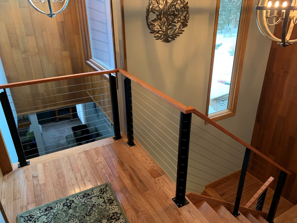 Стильный дизайн: угловая деревянная лестница среднего размера в стиле неоклассика (современная классика) с деревянными ступенями, перилами из тросов и деревянными стенами - последний тренд