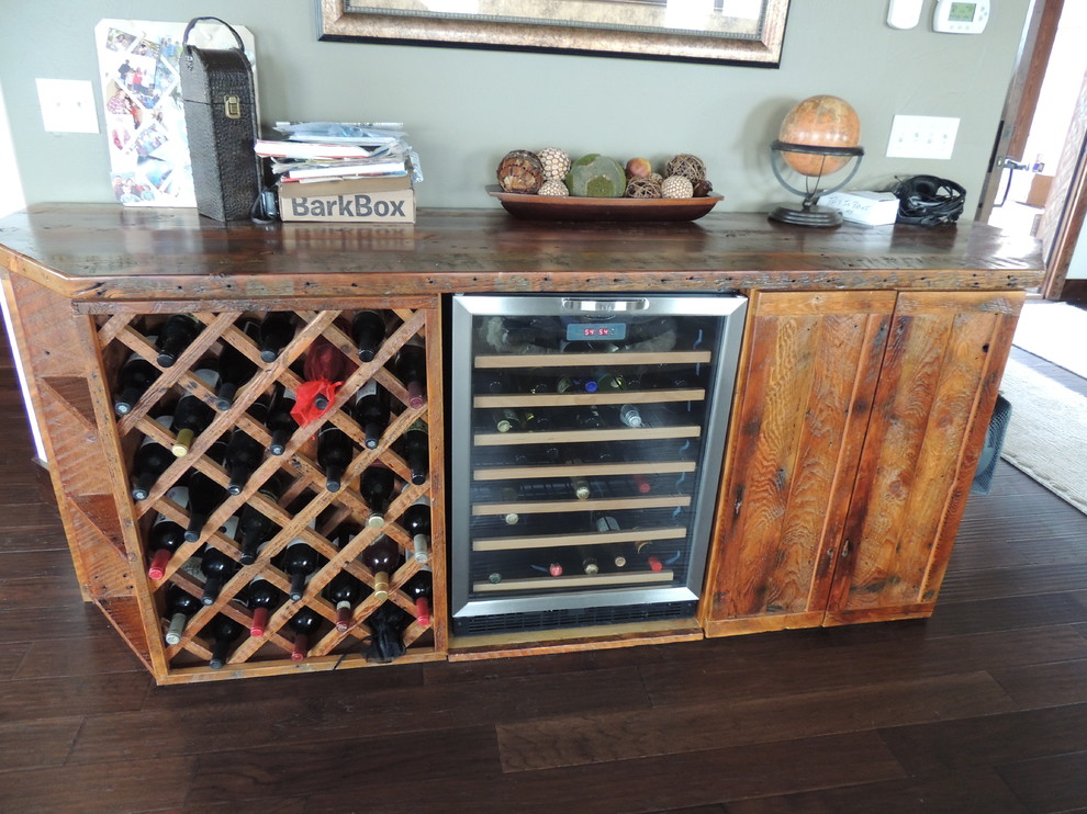 Small country wine cellar in Other with dark hardwood floors and storage racks.