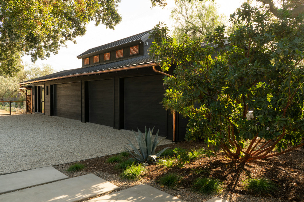 Einstöckige Landhausstil Holzfassade Haus mit schwarzer Fassadenfarbe, Blechdach und braunem Dach in Santa Barbara