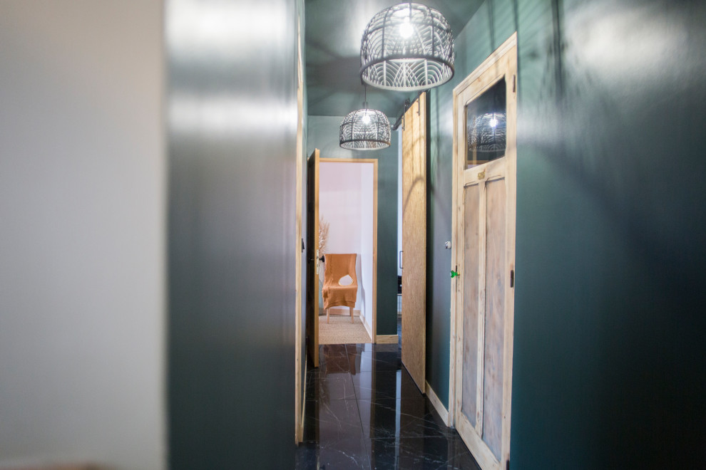 Photo of a country hallway in Le Havre with green walls, marble floors, black floor and coffered.