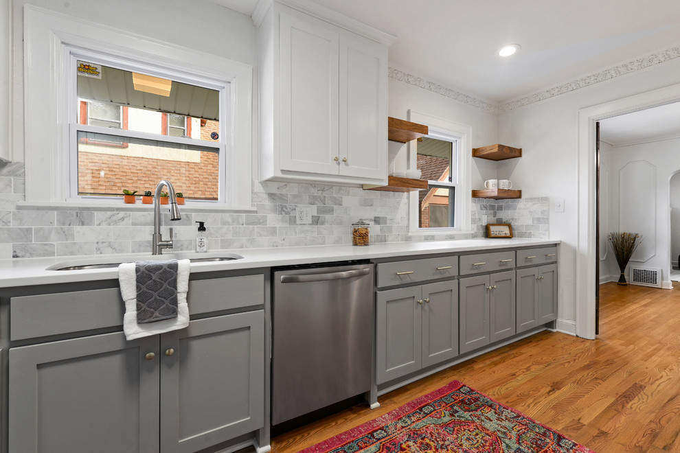 Design ideas for a small traditional single-wall separate kitchen in Kansas City with an undermount sink, recessed-panel cabinets, grey cabinets, quartz benchtops, grey splashback, subway tile splashback, stainless steel appliances, medium hardwood floors and white benchtop.