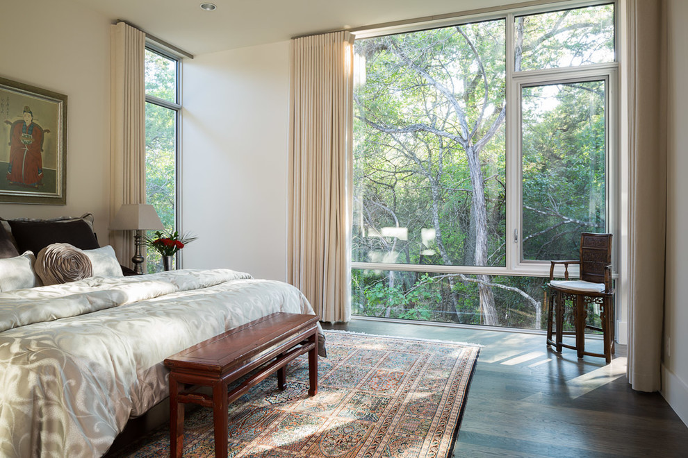 This is an example of a contemporary bedroom in Austin with white walls and dark hardwood floors.