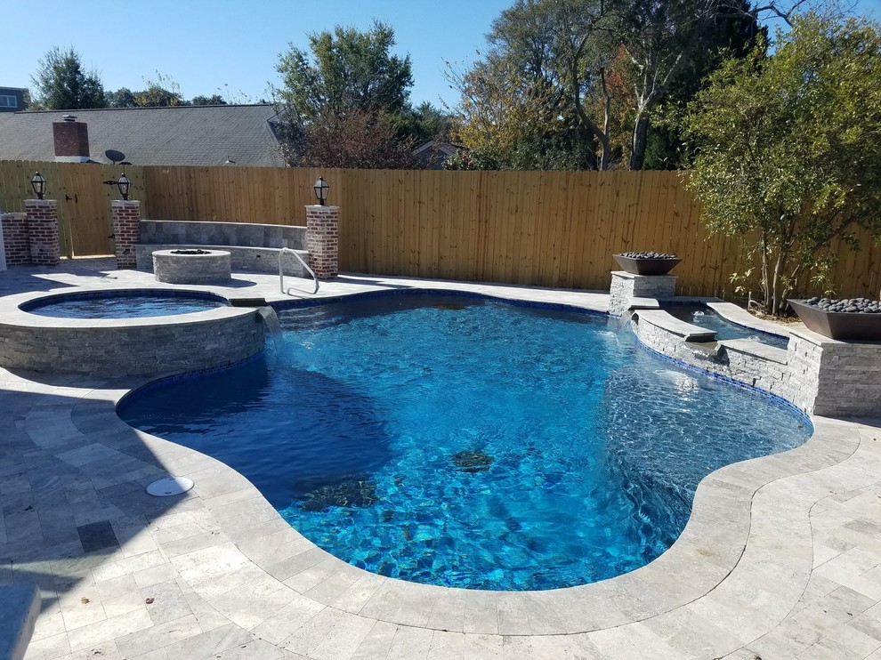 This is an example of a mid-sized contemporary backyard custom-shaped natural pool in Other with a water feature and natural stone pavers.