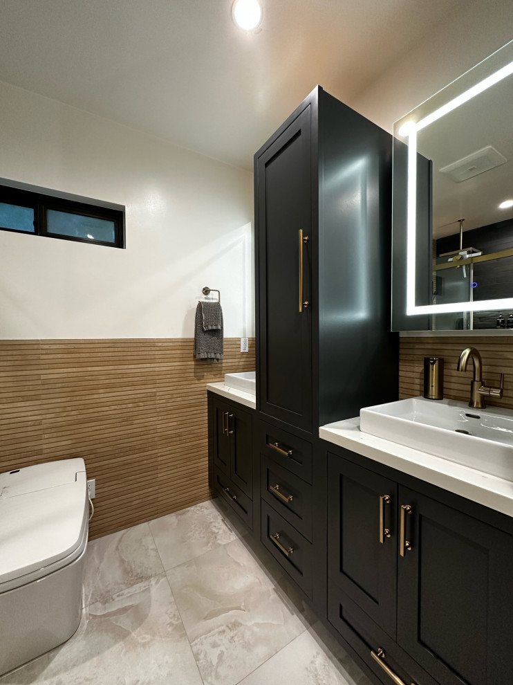 Пример оригинального дизайна: большая ванная комната с фасадами в стиле шейкер, черными фасадами, угловым душем, унитазом-моноблоком, коричневой плиткой, плиткой под дерево, белыми стенами, полом из керамической плитки, душевой кабиной, накладной раковиной, столешницей из кварцита, серым полом, душем с раздвижными дверями, белой столешницей, тумбой под две раковины и напольной тумбой
