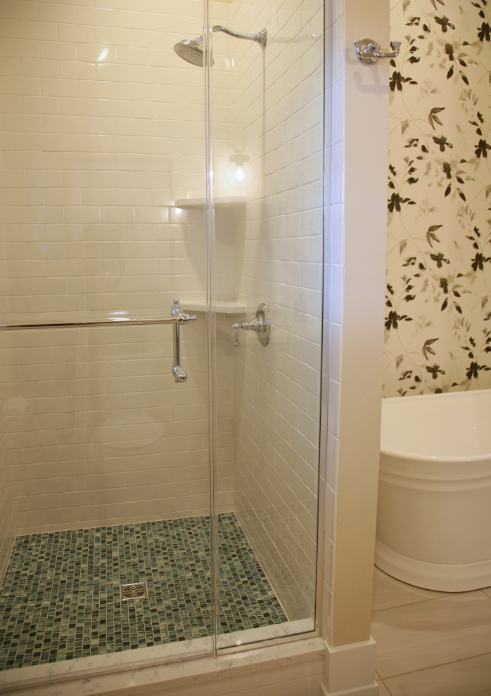 На фото: ванная комната среднего размера в морском стиле с плоскими фасадами, бирюзовыми фасадами, отдельно стоящей ванной, угловым душем, унитазом-моноблоком, белой плиткой, плиткой кабанчик, бежевыми стенами, полом из керамогранита, врезной раковиной, столешницей из искусственного кварца, серым полом, душем с распашными дверями, белой столешницей, тумбой под одну раковину, сводчатым потолком и обоями на стенах