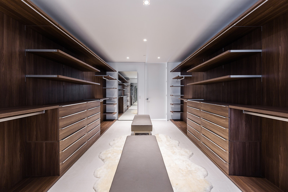 Large contemporary gender-neutral walk-in wardrobe in Los Angeles with flat-panel cabinets, light wood cabinets, ceramic floors and beige floor.