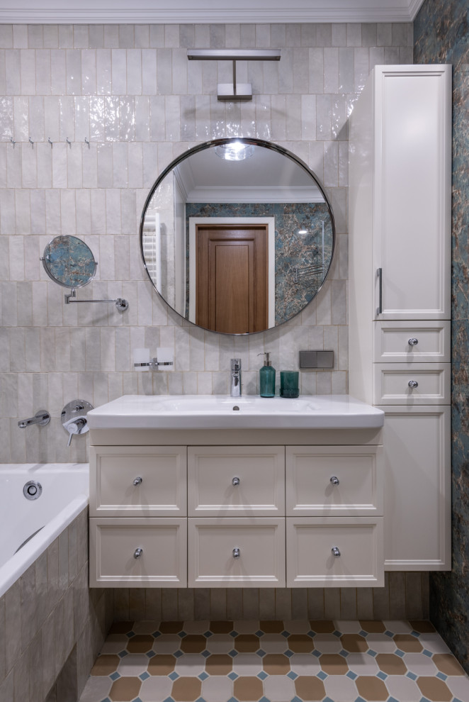 Пример оригинального дизайна: главная, серо-белая ванная комната среднего размера со стиральной машиной в современном стиле с фасадами с утопленной филенкой, белыми фасадами, полновстраиваемой ванной, угловым душем, инсталляцией, бежевой плиткой, керамической плиткой, бежевыми стенами, полом из керамогранита, накладной раковиной, желтым полом, душем с распашными дверями, тумбой под одну раковину и подвесной тумбой