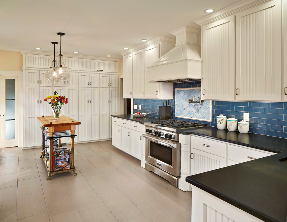 Photo of a traditional u-shaped kitchen in Dallas with recessed-panel cabinets, white cabinets, granite benchtops, blue splashback, subway tile splashback and stainless steel appliances.