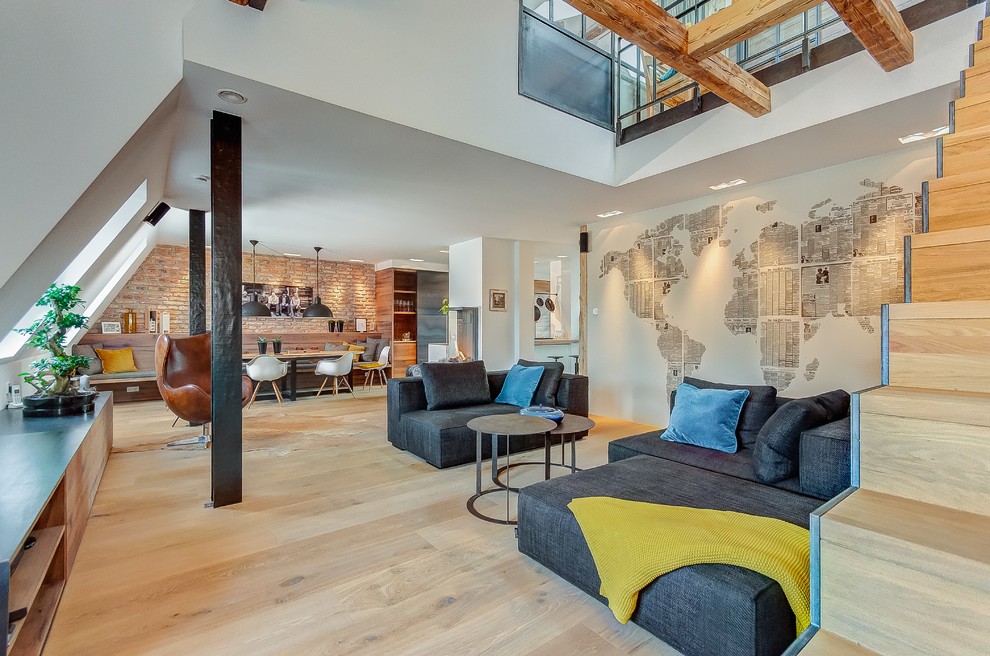 This is an example of a large industrial formal open concept living room in Munich with white walls, a hanging fireplace, a plaster fireplace surround, no tv, brown floor and light hardwood floors.