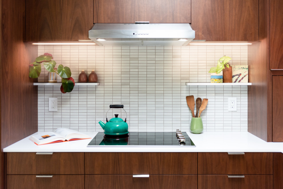 サクラメントにある高級な中くらいなミッドセンチュリースタイルのおしゃれなキッチン (シングルシンク、フラットパネル扉のキャビネット、濃色木目調キャビネット、クオーツストーンカウンター、白いキッチンパネル、セラミックタイルのキッチンパネル、シルバーの調理設備、磁器タイルの床、白い床、白いキッチンカウンター、表し梁) の写真