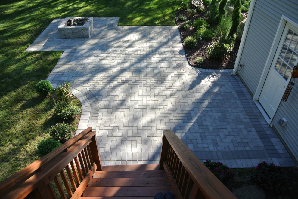This is an example of a mid-sized traditional backyard patio in Providence with a fire feature, concrete pavers and no cover.
