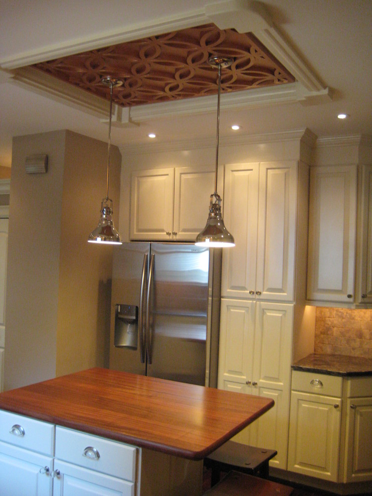 Inspiration for a transitional l-shaped eat-in kitchen remodel in Philadelphia with a single-bowl sink, raised-panel cabinets, white cabinets, granite countertops, brown backsplash, stone tile backsplash and stainless steel appliances