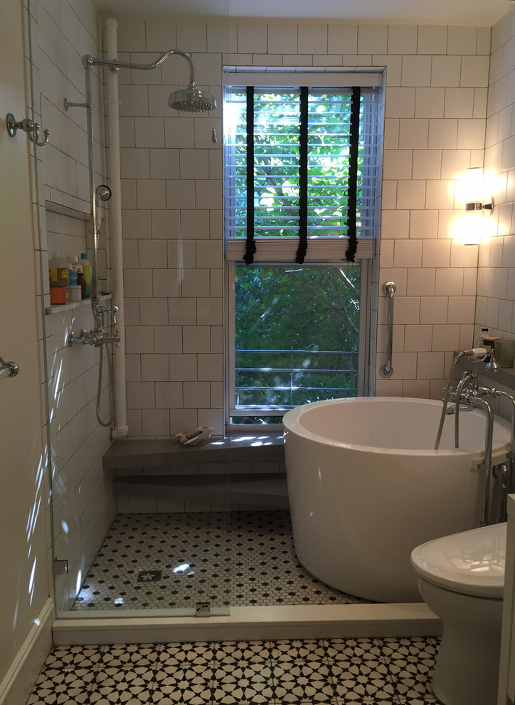 Photo of a mid-sized modern master bathroom in New York with flat-panel cabinets, white cabinets, a japanese tub, an open shower, a bidet, white tile, white walls, solid surface benchtops, ceramic tile, cement tiles and a trough sink.