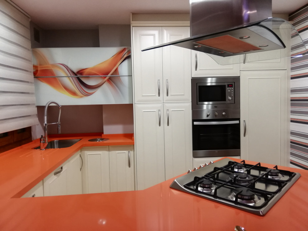 Photo of a small traditional u-shaped eat-in kitchen in Malaga with an undermount sink, beaded inset cabinets, white cabinets, quartz benchtops, stainless steel appliances, terrazzo floors, a peninsula, multi-coloured floor and orange benchtop.