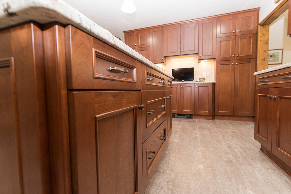 Large elegant l-shaped vinyl floor and beige floor eat-in kitchen photo in Baltimore with an undermount sink, shaker cabinets, medium tone wood cabinets, granite countertops, beige backsplash, ceramic backsplash, stainless steel appliances, an island and white countertops