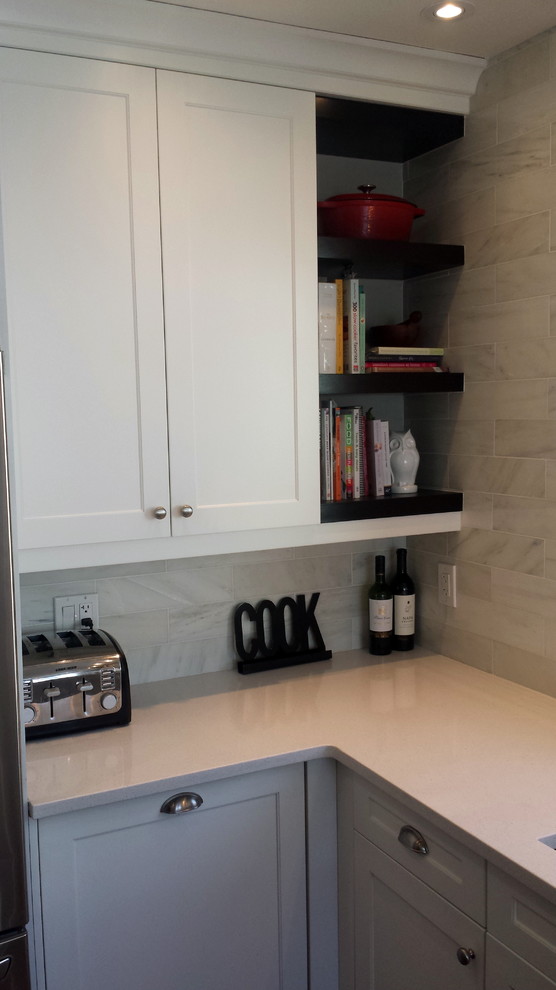 Mid-sized transitional u-shaped dark wood floor enclosed kitchen photo in Ottawa with an undermount sink, shaker cabinets, white cabinets, quartz countertops, white backsplash, subway tile backsplash, stainless steel appliances and a peninsula