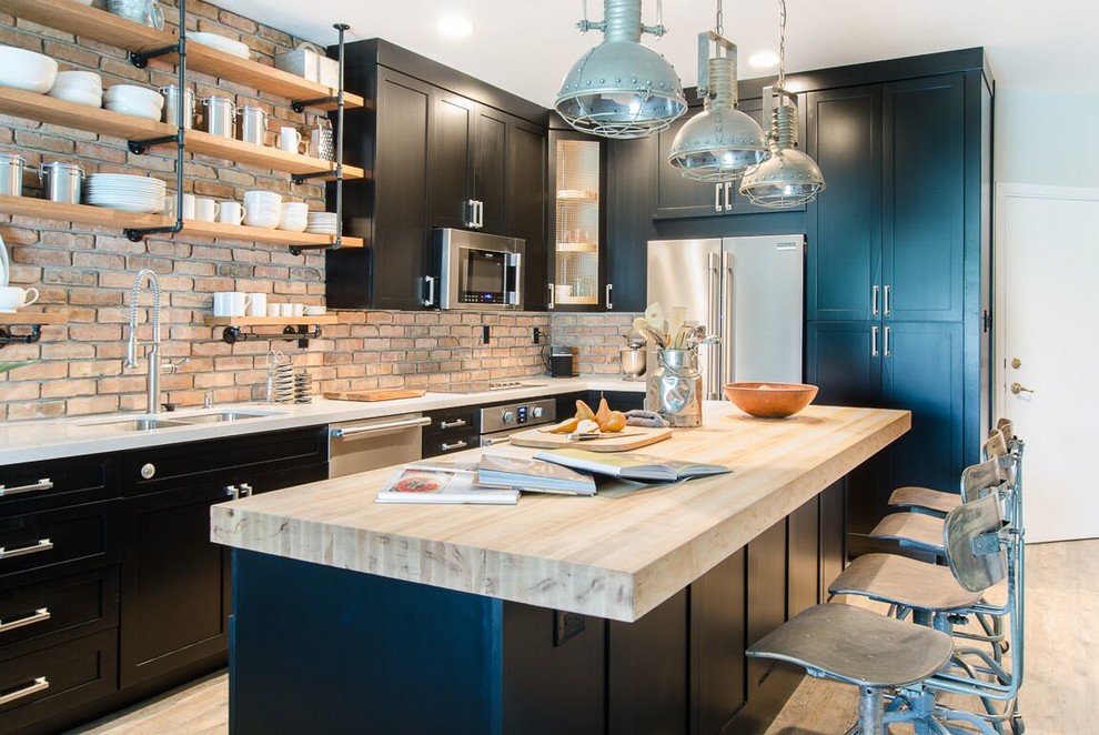 Small industrial kitchen in Miami with a double-bowl sink, shaker cabinets, black cabinets, quartz benchtops, terra-cotta splashback, stainless steel appliances, vinyl floors and with island.